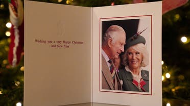 The 2022 Christmas card of Britain's King Charles and Queen Consort Camilla, taken during the Braemar Games September 3, 2022, is displayed in front of a Christmas tree in Clarence House in London, Britain released on December 11, 2022. (Reuters)