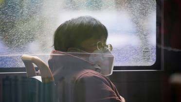 A woman wearing a face mask sits on a bus, as coronavirus disease (COVID-19) outbreaks continue in Shanghai, China, December 12, 2022. REUTERS/Aly Song