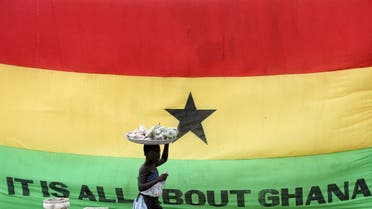 A girl walks past a flag of Ghana outside the Cape Coast Castle, in Ghana. (Reuters)
