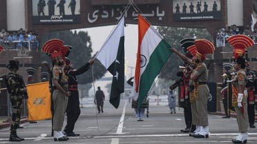 Indian Border Security Force (BSF) personnel and Pakistani Rangers (in black) lower their respective flags during the daily beating of the retreat ceremony at the India-Pakistan Wagah Border Post, about 35 km from Amritsar on November 15, 2021. (AFP)