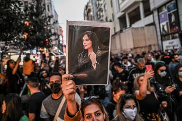 A protester holds a portrait of Mahsa Amini during a demonstration in support of Amini, a young Iranian woman who died after being arrested in Tehran by the Islamic Republic’s morality police, on Istiklal avenue in Istanbul on September 20, 2022. (AFP)