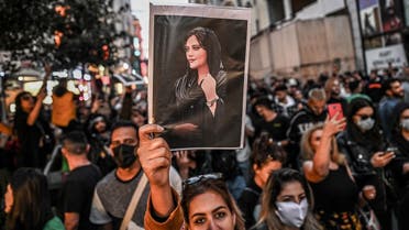A protester holds a portrait of Mahsa Amini during a demonstration in support of Amini, a young Iranian woman who died after being arrested in Tehran by the Islamic Republic’s morality police, on Istiklal avenue in Istanbul on September 20, 2022. (AFP)