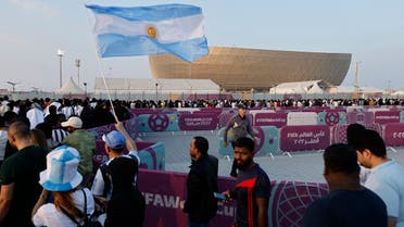 A fan holds an Argentina flag outside the stadium before the FIFA World Cup Qatar 2022 final match between Argentina and France at the Lusail Stadium, Lusail, Qatar, on December 18, 2022. (Reuters)