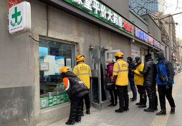 Delivery workers wait outside a pharmacy to pick up orders as coronavirus disease (COVID-19) outbreaks continue in Beijing, on December 20, 2022. (Reuters)