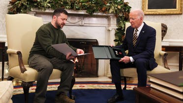Ukraine's President Volodymyr Zelenskiy delivers a soldier's gift to U.S. President Joe Biden in the Oval Office at the White House in Washington, U.S., December 21, 2022. (Reuters)
