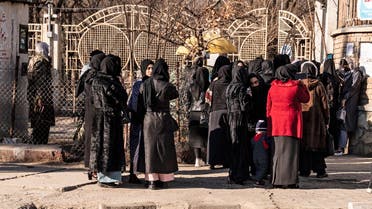 Afghan female university students stop by Taliban security personnel stand next to a university in Kabul on December 21, 2022. (AFP)