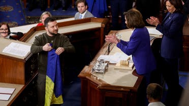 Ukraine's President Volodymyr Zelenskiy presents a Ukrainian flag given to him by defenders of Bakhmut to U.S. House Speaker Nancy Pelosi (D-CA), while U.S. Vice President Kamala Harris applauds during a joint meeting of U.S. Congress in the House Chamber of the U.S. Capitol in Washington, U.S., December 21, 2022. (Reuters)
