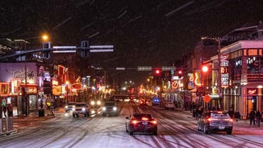 Snow falls on Broadway, a popular tourist street in Nashville, Tennessee, on December 22, 2022. (AFP)