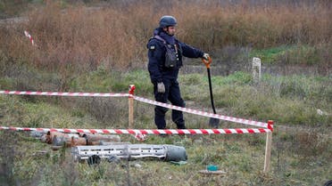 A Ukrainian mine expert stands next to unexploded ordnance and landmines by the main road to Kherson, Ukraine November 16, 2022. REUTERS/Murad Sezer