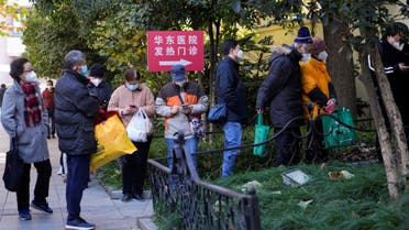 People wearing protective masks line up outside a fever clinic of a hospital, as coronavirus disease (COVID-19) outbreaks continue in Shanghai, China, December 20, 2022. (Reuters)