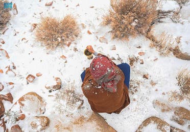 Aerial view shows a man holding a cup of coffee as snow falls in Tabuk, Saudi Arabia, on December 27. (SPA)