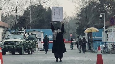 This picture taken on December 25, 2022 shows student Marwa protesting alone against the ban on women’s higher education, outside the Kabul University as members of Taliban stand guard in Kabul. (AFP)