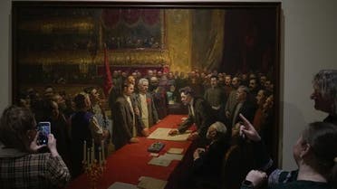 Visitors look at the painting, The signing of the treaty on the formation of the USSR on December 30, 1922 in the Bolshoi Theater by Stepan Dudnik at the State Central Museum of Contemporary History of Russia in Moscow, Russia, Wednesday, Dec. 21, 2022.  (AP)