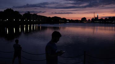 People are seen using their phones at sunset in the Docklands, following the outbreak of the coronavirus disease (COVID-19), London, Britain, May 26, 2020. (File photo: Reuters)