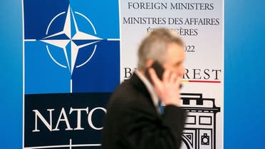 A man walks past the NATO logo during the meeting of the NATO Ministers of Foreign Affairs in Bucharest, Romania, on November 30, 2022. (Reuters)