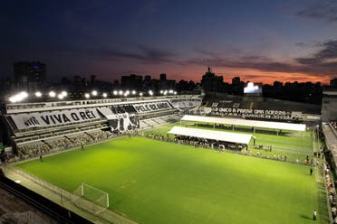 General view at the stadium as dusk falls in Vila Belmiro as mourners queue to pay their respect during his funeral tribute. (Reuetrs)