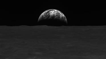 This handout image taken on December 31, 2022 and provided by the Korea Aerospace Research Institute (KARI) on January 3, 2023 shows a black-and-white image of the lunar surface and Earth taken by South Korean lunar orbiter Danuri after reaching the moon’s orbit. (AFP)