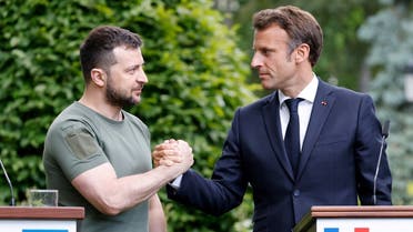 Ukrainian President Volodymyr Zelenskyy (L) and French President Emmanuel Macron shake hands after giving a press conference in at Mariinsky Palace in Kyiv, on June 16, 2022. (AFP)
