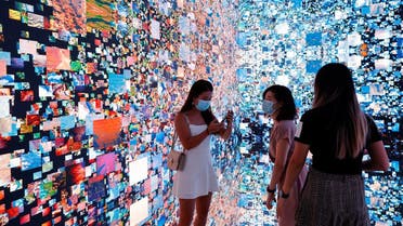 Visitors are pictured in front of an immersive art installation titled “Machine Hallucinations — Space: Metaverse” by media artist Refik Anadol, which will be converted into NFT and auctioned online at Sotheby's, at the Digital Art Fair, in Hong Kong, China. (Reuters)