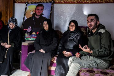 Samira (2nd-R), the 55-year-old mother of Palestinian Yunis al-Shaer, one of eight young Palestinian men who drowned two months prior off the coast of Tunisia in a clandestine migration attempt to Europe, looks on as his brother Mohamed (R) speaks during an interview at her house in Rafah the southern Gaza Strip on December 20, 2022. (AFP)