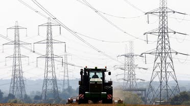 A farmer works in a field surrounded by electricity pylons in Ratcliffe-on-Soar, in central England, September 10, 2014. (Reuters)