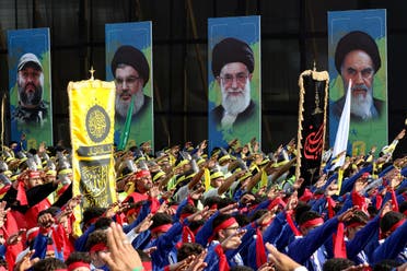 Scouts loyal to the Lebanese Shia Hezbollah movement, taking part in a procession on the 13th of Muharram on the Islamic calendar, raise their arms in salute as they march past posters of (L to R) Hezbollah’s slain military leader Imad Moghniyeh, current leader Hassan Nasrallah, Iran’s Supreme Leader Ali Khamenei and late Supreme Leader Ruhollah Khomeini, in Lebanon’s southern city of Nabatiyeh on August 12, 2022. (AFP)