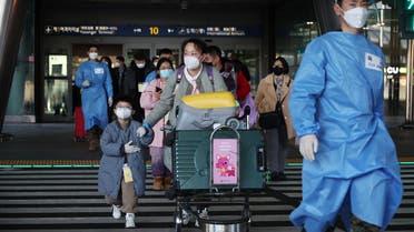 A South Korean soldier wearing personal protective equipment (PPE) leads a group of Chinese tourists to the coronavirus disease (COVID-19) testing centre upon their arrival at the Incheon International Airport, in Incheon, South Korea, January 12, 2023. (Reuters)