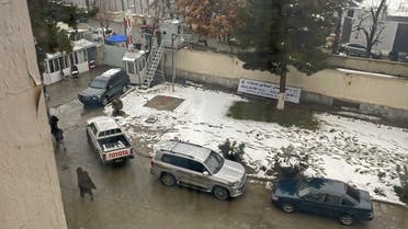 People walk past the parked vehicles after a suicide blast near Afghanistan's foreign ministry in Kabul on January 11, 2023. A suicide bomber detonated a device on January 11 near Afghanistan's foreign ministry in the capital, causing more than 20 causalities, an AFP staff member said. (Photo by AFP)
