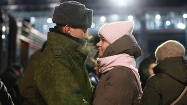 A couple embrace as other soldiers who were recently mobilized by Russia for the military operation in Ukraine stand at a ceremony before boarding a train at a railway station in Tyumen, Russia, Friday, Dec. 2, 2022. Russian President Vladimir Putin's order to mobilize reservists for the conflict prompted large numbers of Russians to leave the country. (AP Photo)