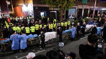 Rescue team members wait with stretchers to remove bodies from the scene where dozens of people were injured in a stampede during a Halloween festival in Seoul, South Korea, October 30, 2022. REUTERS/Kim Hong-ji REFILE - CORRECTING DATE