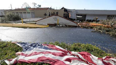 The American flag lies in the shrubs in front of the storm damaged Selma Country Club after a tornado ripped through Selma, Alabama, U.S. January 12, 2023. (AFP)