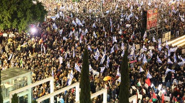 Israeli left wing protesters wave the national flag during a rally against Prime Minister Benjamin Netanyahu's new hard-right government in the coastal city of Tel Aviv on January 14, 2023. (AFP)