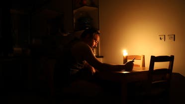 Amid, an Iranian student, reads books at home while electricity is cut off due to energy savings in Tehran, Iran, July 5, 2021. (File photo: Reuters)