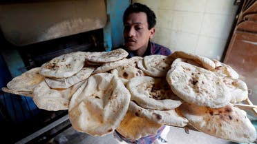 A baker carries bread in El-Kalubia governorate, northeast of Cairo, March 1, 2022. (File photo: Reuters)