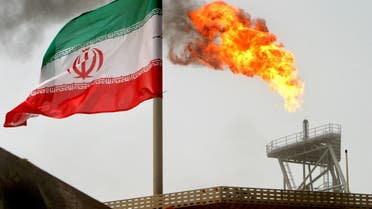FILE PHOTO: A gas flare on an oil production platform is seen alongside an Iranian flag in the Gulf July 25, 2005. REUTERS/Raheb Homavandi/File Photo