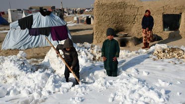Afghan internally-displaced children shovel snow near their tents during a cold winter day at Nahr-e Shah-e- district of Balkh Province, near Mazar-i-Sharif on January 17, 2023. (AFP)