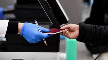 A passenger gives his passport to a worker, after Italy has ordered coronavirus disease (COVID-19) antigen swabs and virus sequencing for all travellers coming from China, where cases are surging, at the Malpensa Airport in Milan, Italy, December 29, 2022. (File photo: Reuters)
