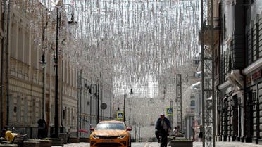 A man rides his bicycle as a taxi drives along a street in Moscow, Russia June 9, 2020. REUTERS