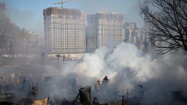 Firefighters work at the scene of a fire at Guryong village, the last slum in the glitzy Gangnam district, as apartment complexes which are currently under construction are seen in the background, in Seoul, South Korea, January 20, 2023. REUTERS/Kim Hong-Ji TPX IMAGES OF THE DAY