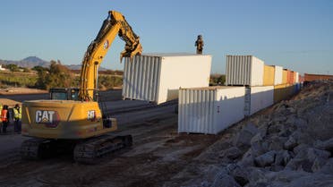A construction crew removes shipping containers after outgoing Governor Doug Ducey, who had recently authorized the placement of shipping containers along the border between US and Mexico to stem illegal migration, ordered their removal following a White House lawsuit, in Yuma County, Arizona, US, January 3, 2023. (Reuters)