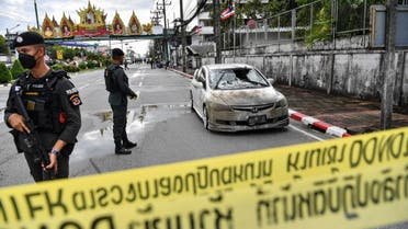 Police officials stand near a partly damaged car, after a car bomb exploded outside a police accommodation in Muang district in Thailand's southern province of Narathiwat on November 22, 2022. One person died and more than two dozen were injured in the attack, the provincial governor said. (Photo by Madaree TOHLALA / AFP)