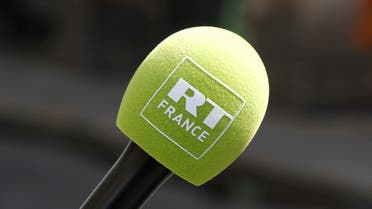 A reporter holds a microphone with a logo of RT France, formerly known as Russia Today during May Day celebrations in Paris, France, May 1, 2018. (Reuters)