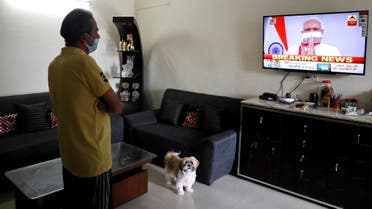 A man watches India's Prime Minister Narendra Modi’s address to the nation on a television announcing the extension of a nationwide lockdown till May 3, to limit the spreading of coronavirus disease (COVID-19), in in New Delhi, India, April 14, 2020. (Reuters)