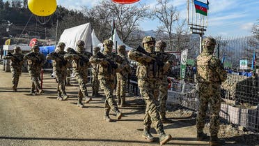Azerbaijani servicemen march at a checkpoint at the Lachin corridor, the Armenian-populated breakaway Nagorno-Karabakh region's only land link with Armenia, Dec. 27, 2022. (AFP)