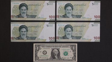A US one-dollar bill is seen against four 10,000 Iranian rial bills in an exchange shop in Tehran, Iran on December 25, 2022. (West Asia News Agency via Reuters)