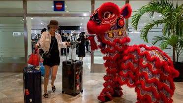 A dragon dance performer greets a traveler from China at the Ninoy Aquino International Airport, in Pasay City, Metro Manila, Philippines, January 24, 2023. REUTERS/Lisa Marie David