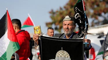 خان احمر میں احتجاج کے دوران مظاہرین نے فلسطینی پرچم اٹھا رکھا ہے