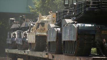 M1 Abrams tanks and other armored vehicles sit atop flat cars in a rail yard in Washington, July 2, 2019. (Reuters)