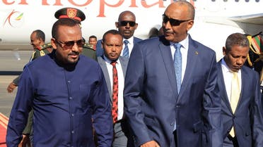 Ethiopian Prime Minister Abiy Ahmed (l) walks alongside Sudanese Army Chief Abdel Fattah al-Burhan (C) at Khartoum Airport during a welcome ceremony on January 26, 2023. (AFP)