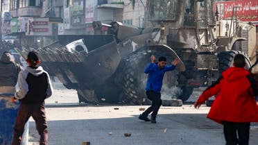 Palestinians hurl rocks at an Israeli army bulldozer, during confrontations in the occupied-West Bank city of Jenin, on January 26, 2023. (AFP)